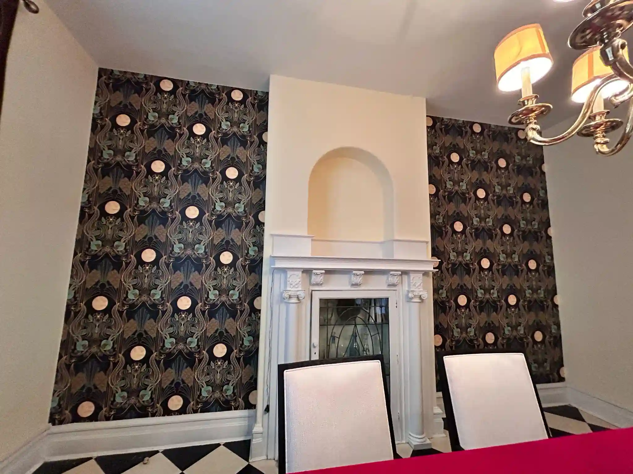 Dark ornamental wallpaper framing a dining-room alcove.